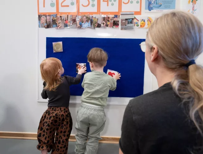 Billedet viser to børn, der taler om billeder på en tavle